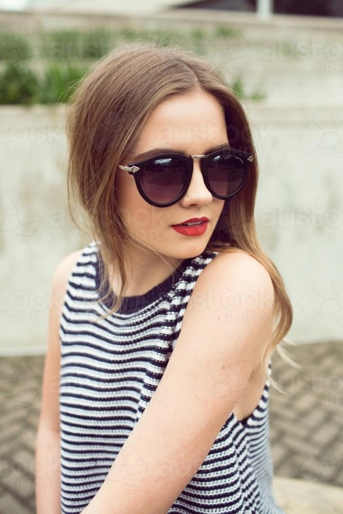 Young blonde woman posing wearing sunglasses - Australian Stock Image