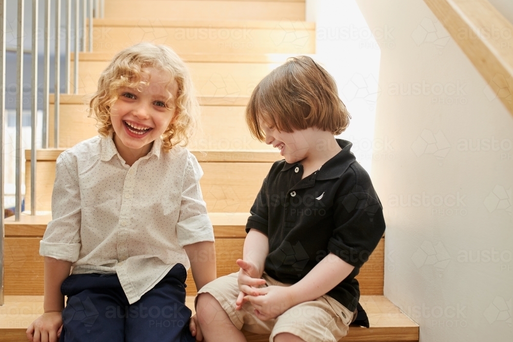Young boy and girl sitting on stairs - Australian Stock Image