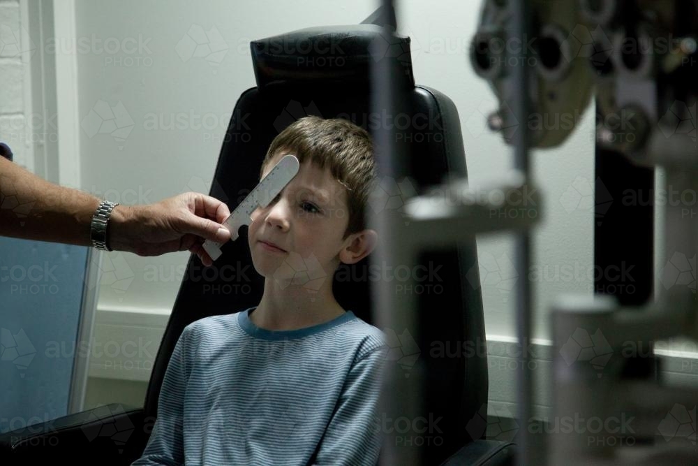 Young boy at an optometrist appointment getting his vision tested - Australian Stock Image