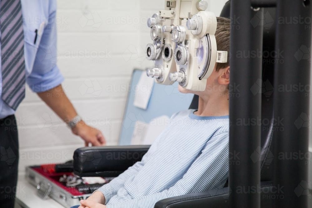 Young boy at an optometrist appointment getting his vision tested - Australian Stock Image