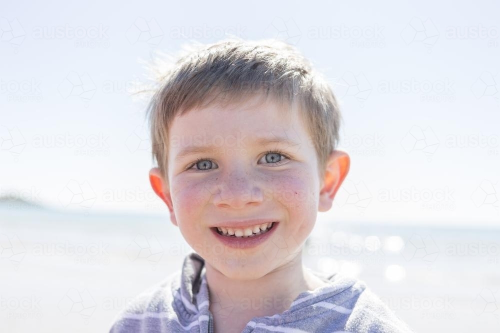 Young boy at the beach smiling - Australian Stock Image