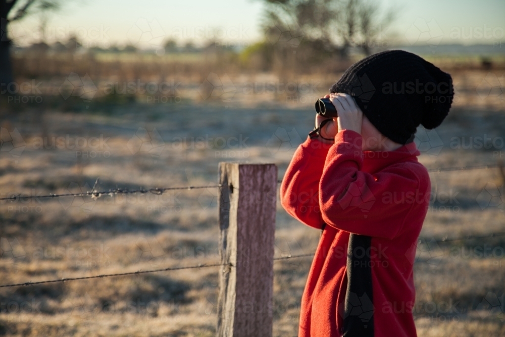 Young boy bird watching on cold winter morning - Australian Stock Image
