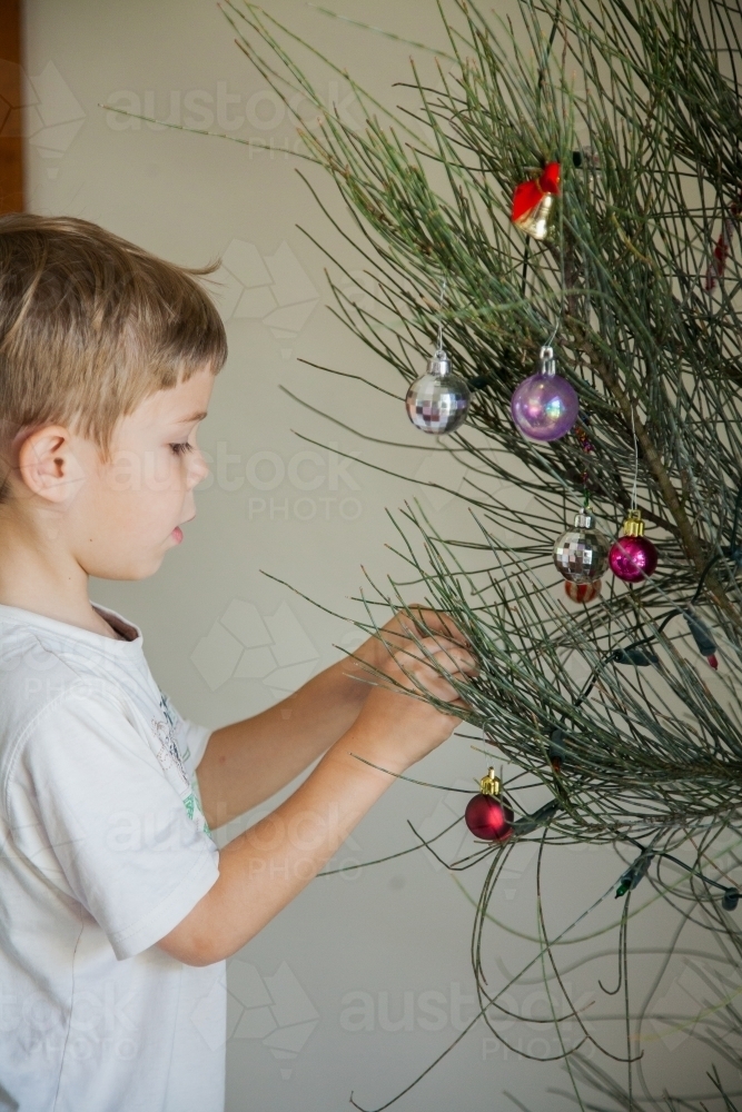Young boy decorating a live Christmas tree - Australian Stock Image