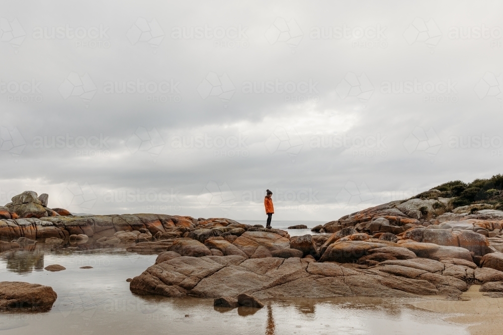 Young boy exploring coastal rocks - Australian Stock Image