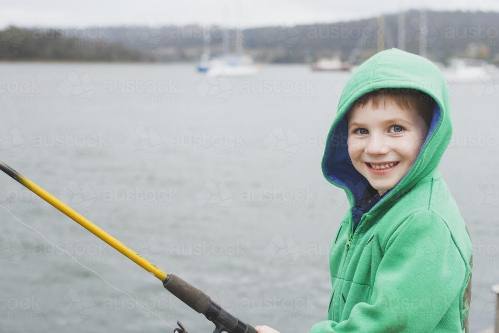 Young boy happily fishing - Australian Stock Image