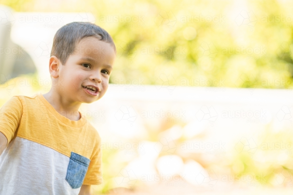 Young boy happily playing outside - Australian Stock Image