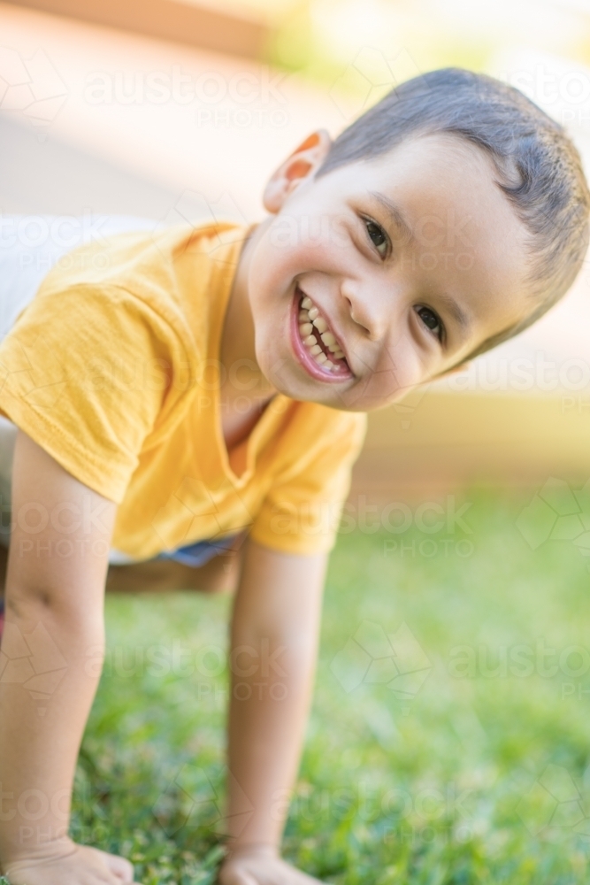 Young boy happily playing outside - Australian Stock Image