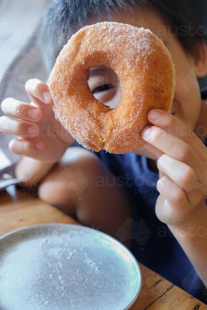 Young boy holding a doughnut - Australian Stock Image