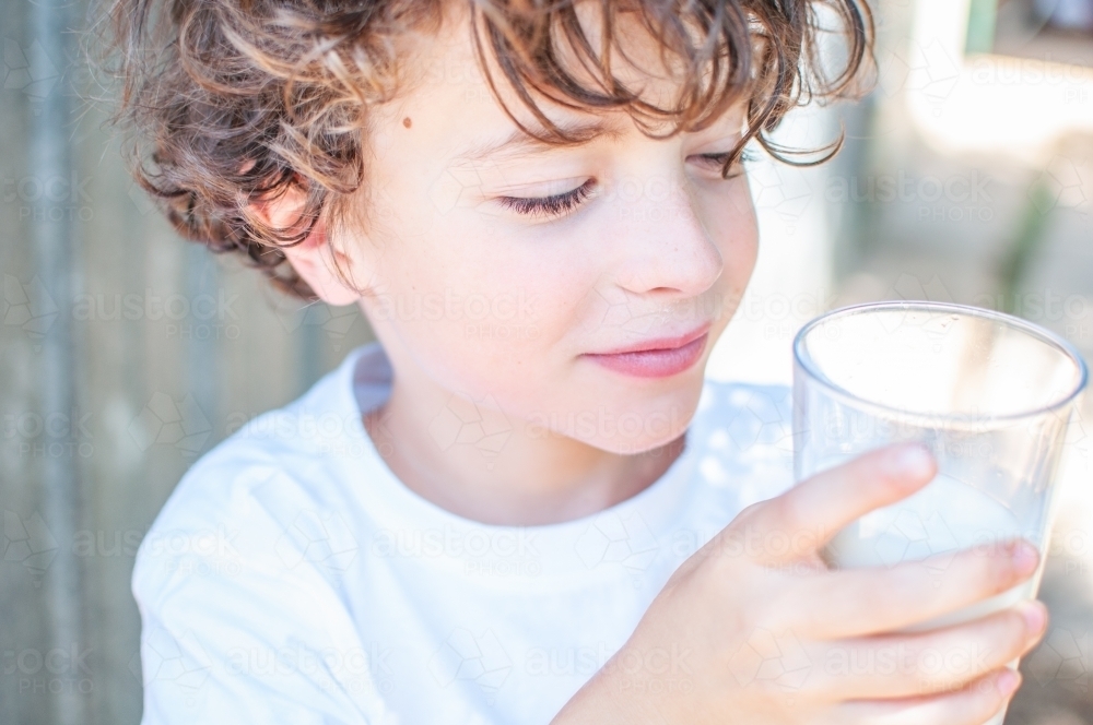Young boy holding a glass of milk - Australian Stock Image