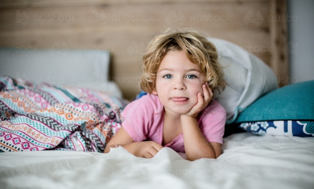 Young boy in bed in natural morning light - Australian Stock Image