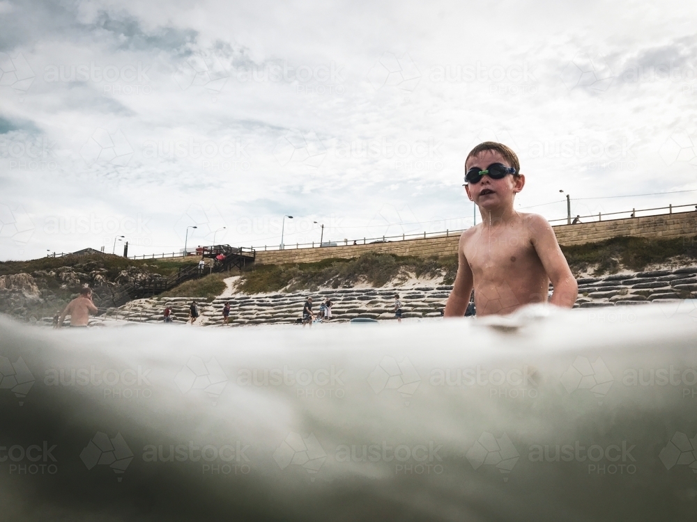 Young boy in ocean wearing goggles - Australian Stock Image