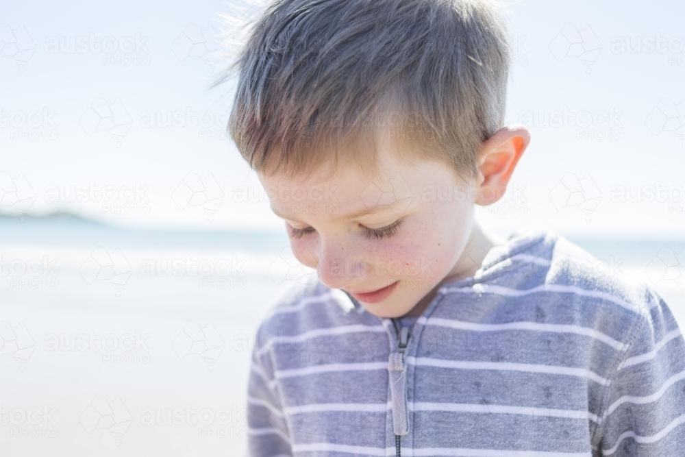 Young boy looking down at the beach - Australian Stock Image