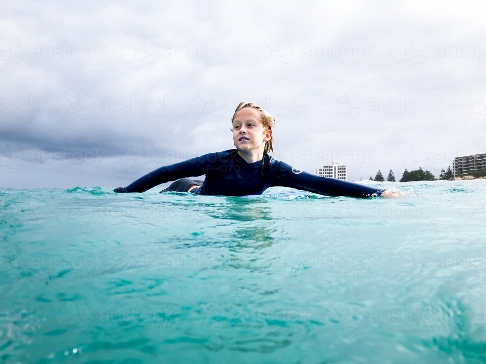 Young boy on board in ocean water - Australian Stock Image