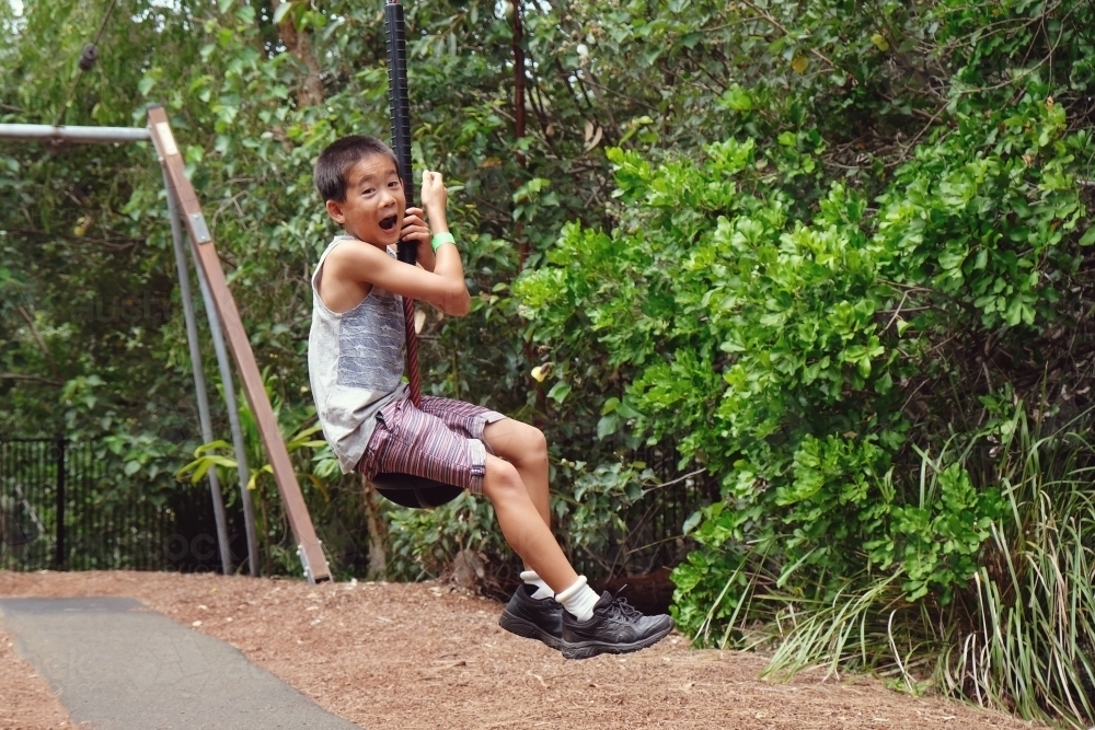 Young boy on flying fox at playground - Australian Stock Image