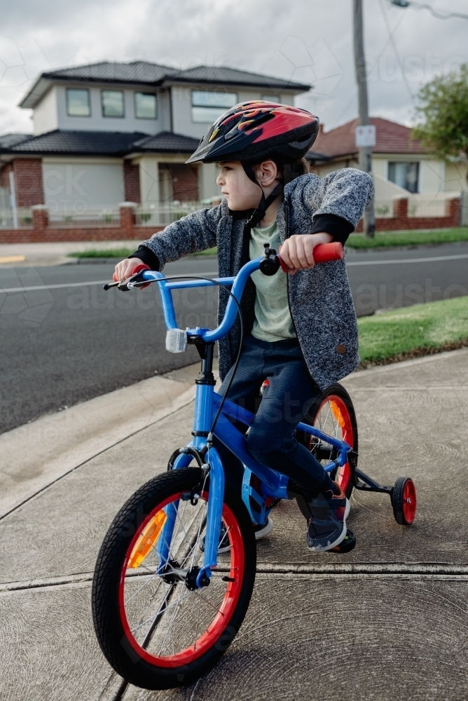 Young boy on his bicycle wearing a bike helmet, cycling around suburban Melbourne - Australian Stock Image