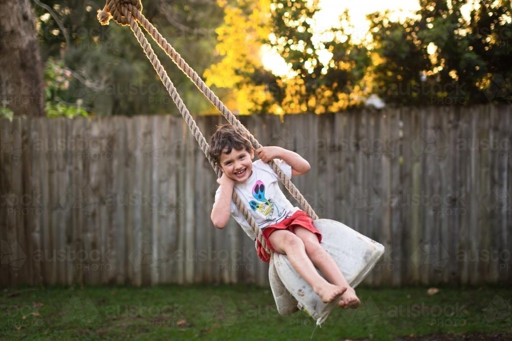 Young boy on rope swing - Australian Stock Image