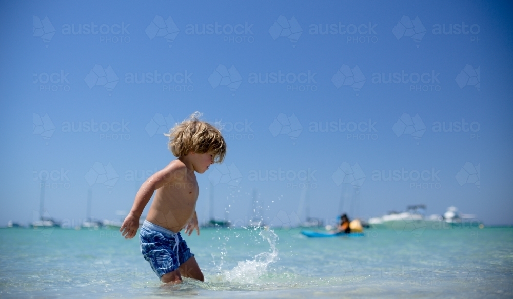 Young boy playing at beach - Australian Stock Image
