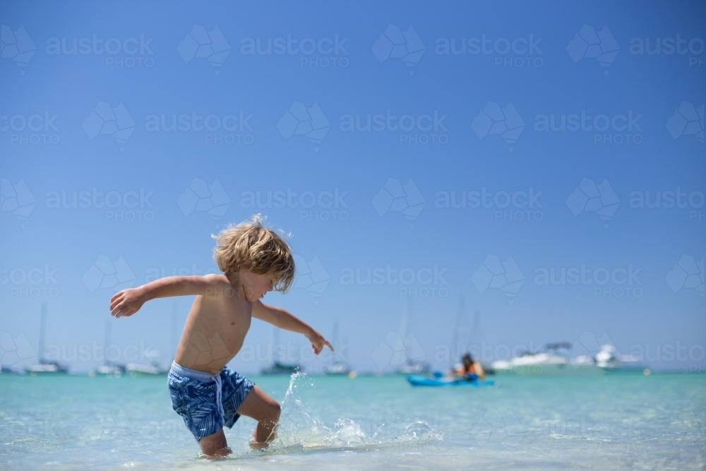 Young boy playing at beach - Australian Stock Image