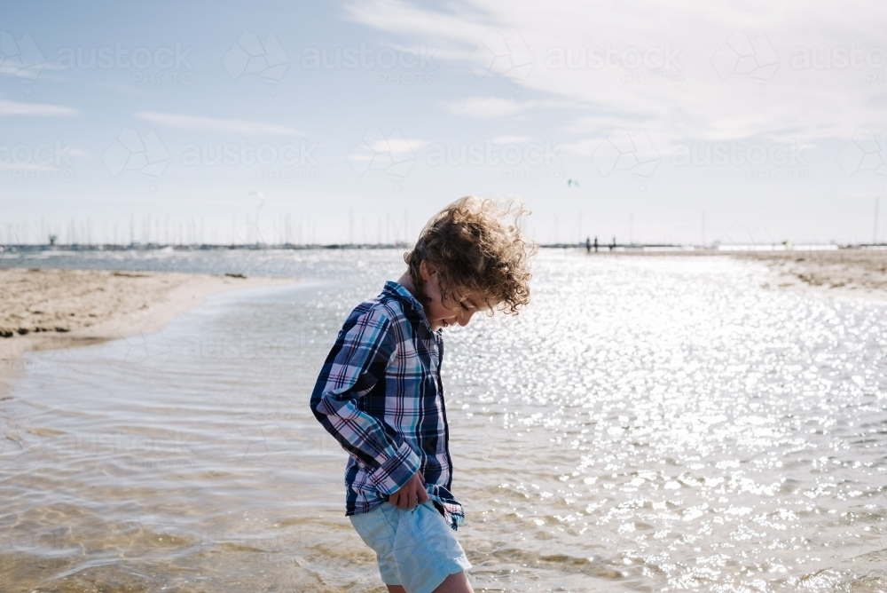 Young boy walking in the water at the beach, St Kilda - Australian Stock Image