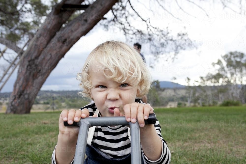 Young boy playing intently outside - Australian Stock Image