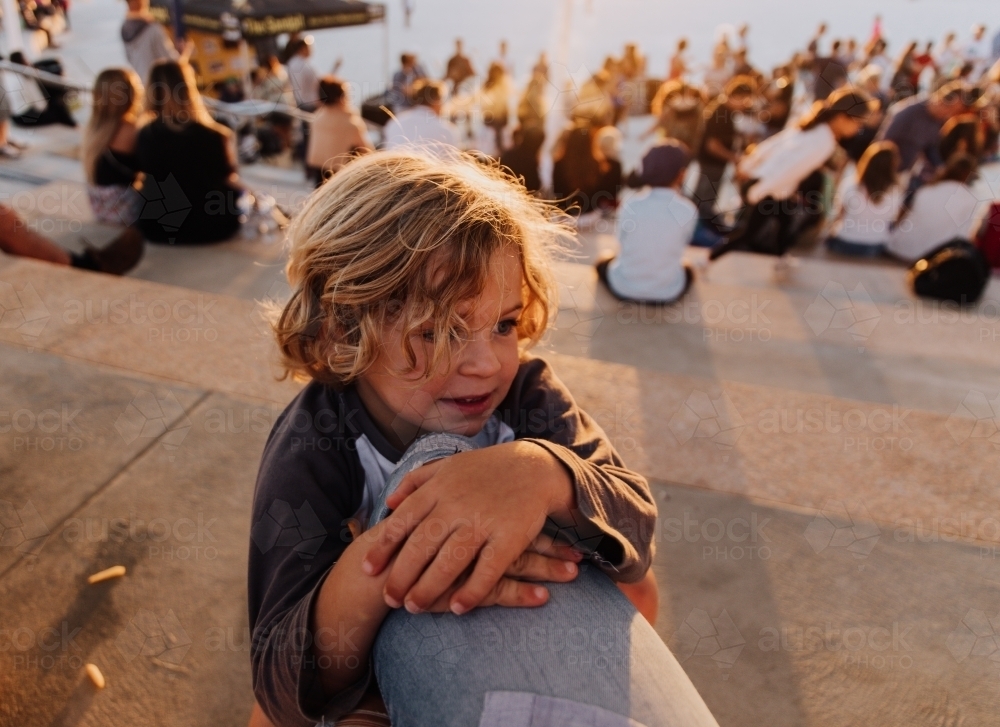 Young boy playing on mums leg - Australian Stock Image