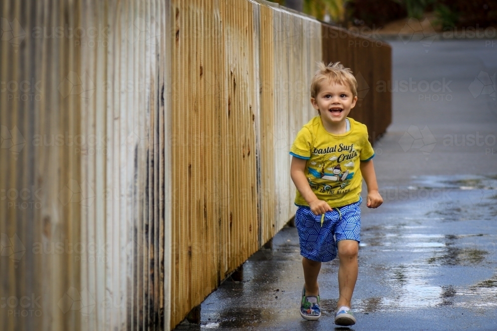 Young boy running and laughing - Australian Stock Image