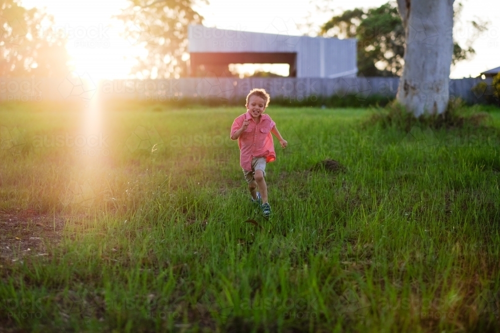 Young boy running in field - Australian Stock Image