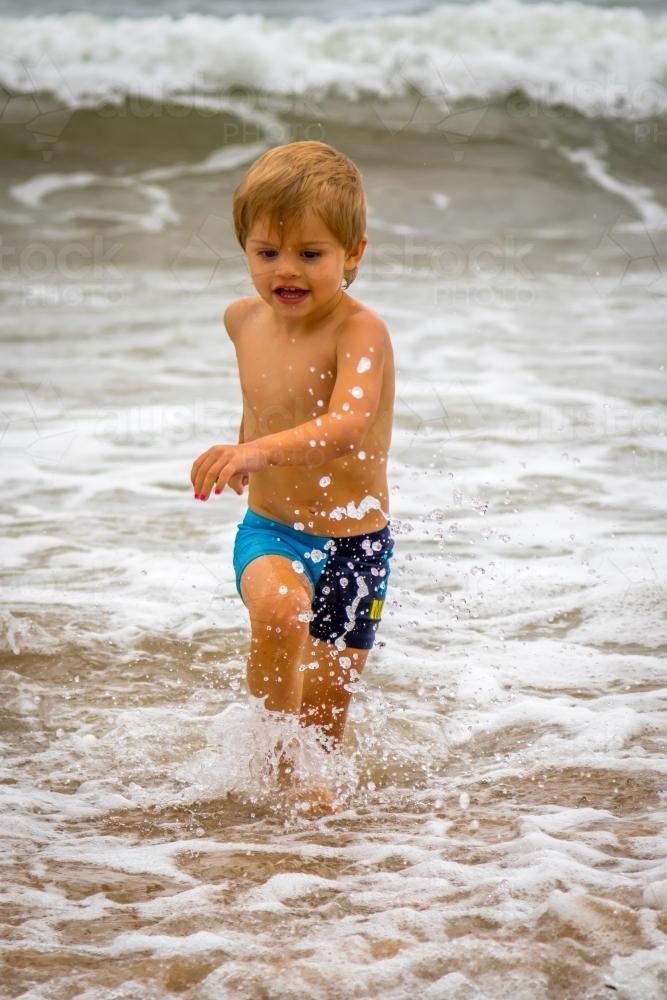 Young boy running in the surf - Australian Stock Image
