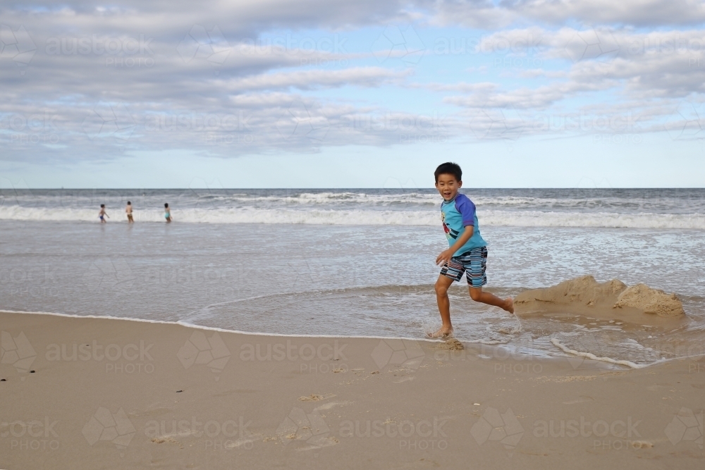 Young boy running on the beach - Australian Stock Image