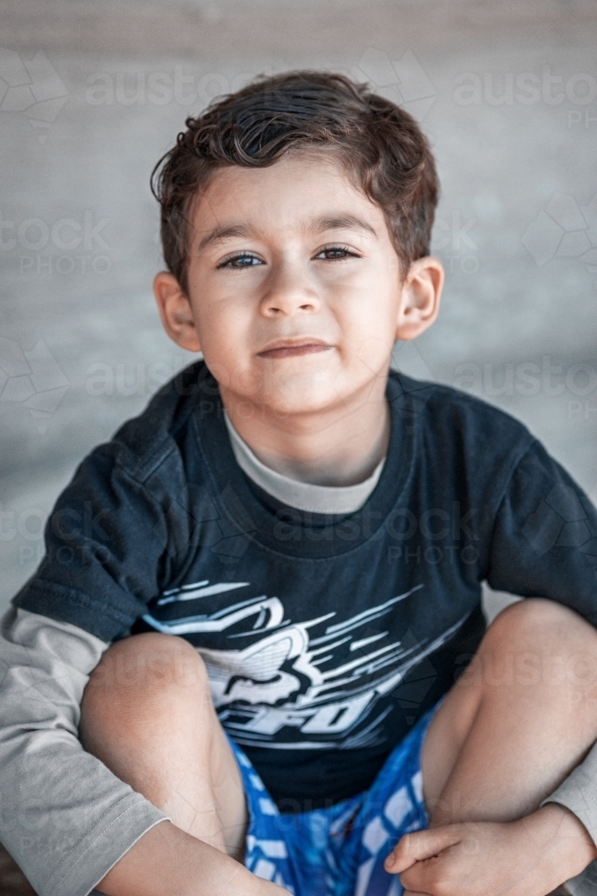 Young boy seated looking at camera - Australian Stock Image