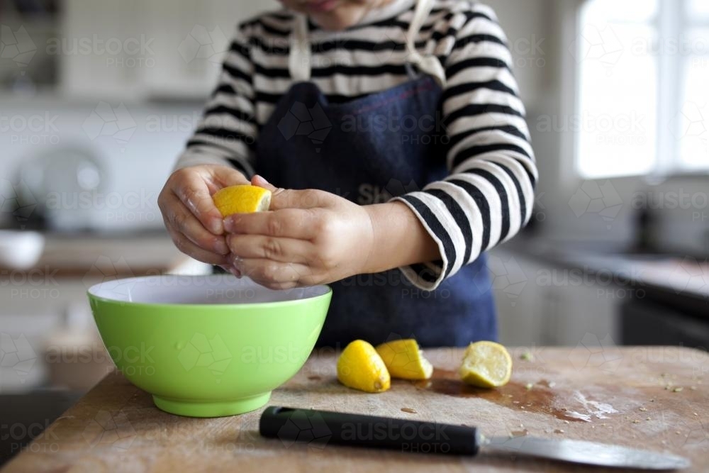 Young boy squeezing lemons into a bowl - Australian Stock Image
