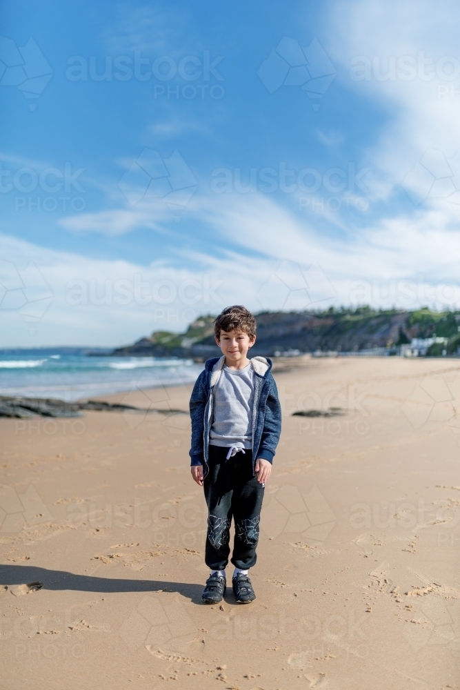 Young boy standing on beach - Australian Stock Image