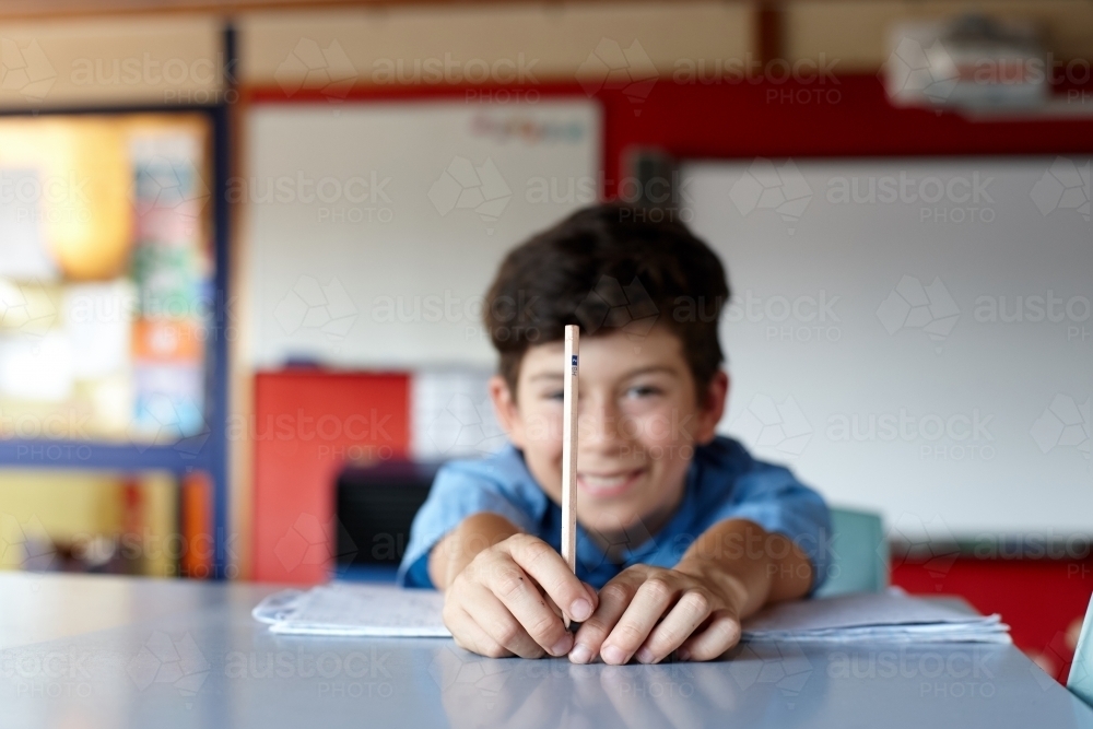Young boy student in school classroom holding HB pencil - Australian Stock Image