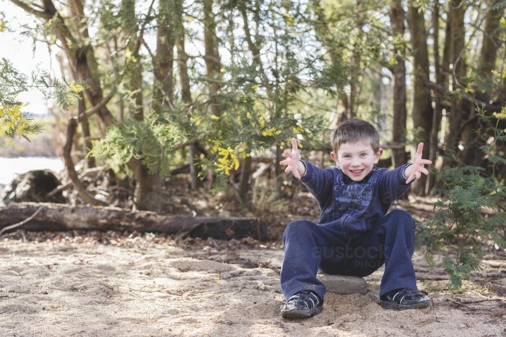 Young boy throwing sand in the air - Australian Stock Image