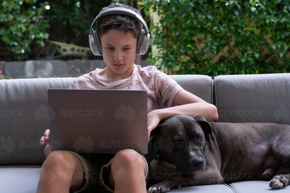 Young boy using laptop outside - Australian Stock Image