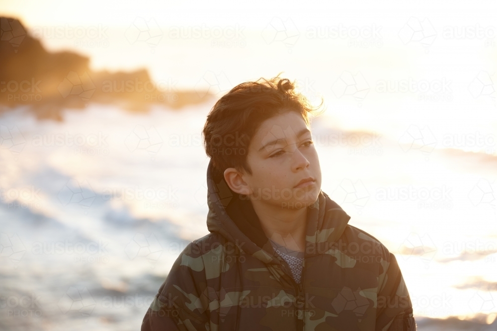 Young boy wearing camo jacket on sunrise - Australian Stock Image