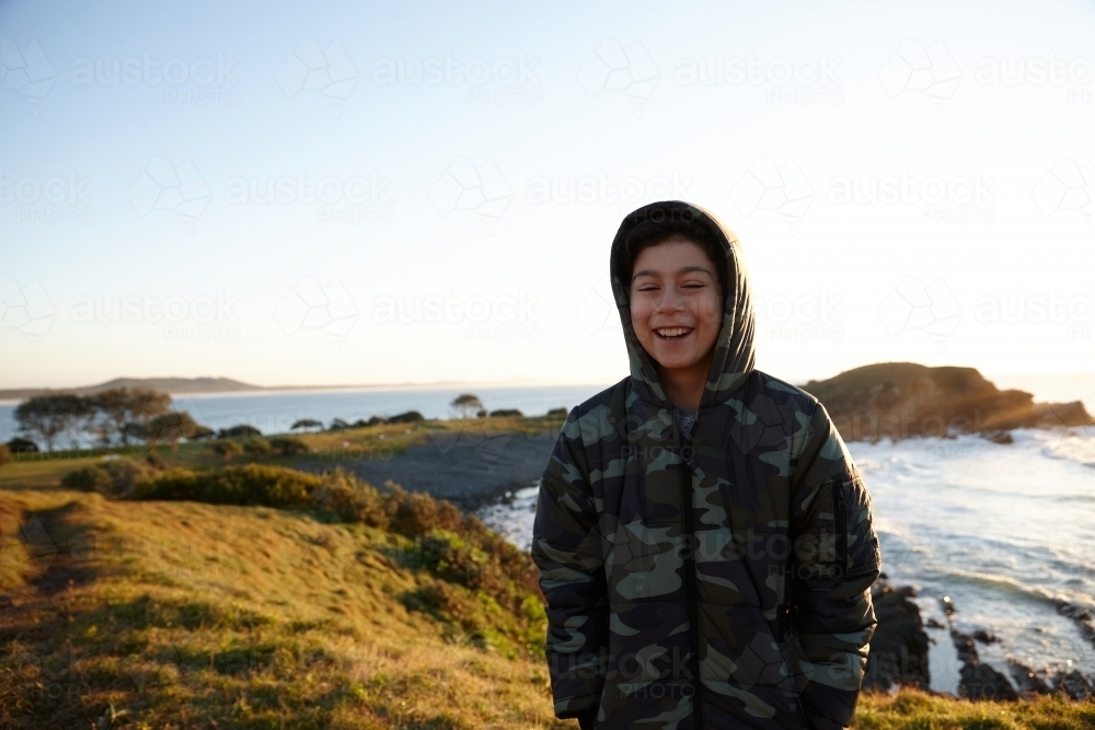 Young boy wearing camo jacket on sunrise - Australian Stock Image