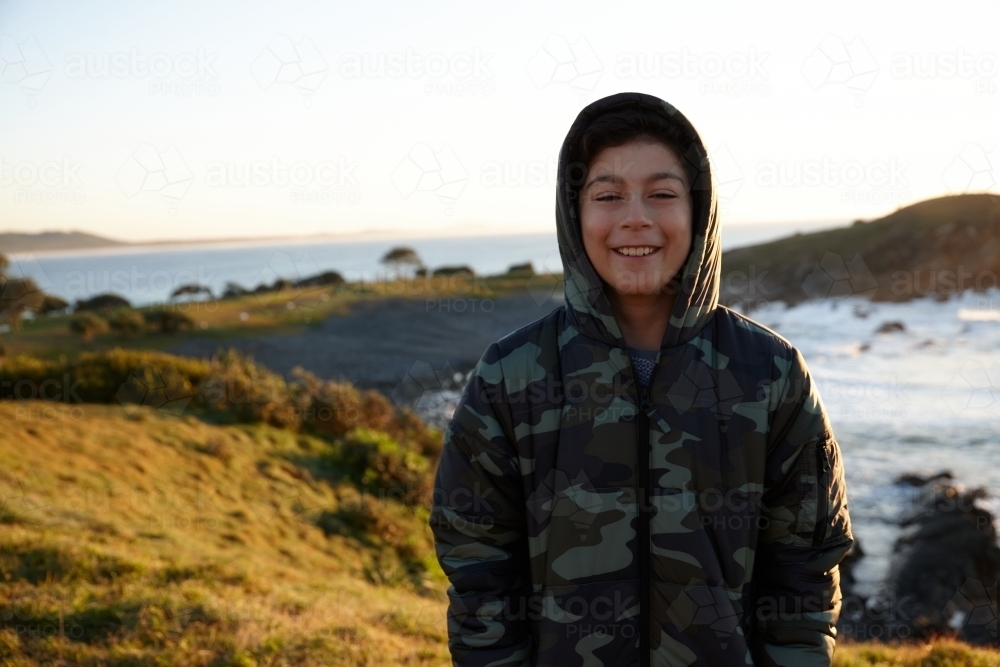 Young boy wearing camo jacket on sunrise - Australian Stock Image