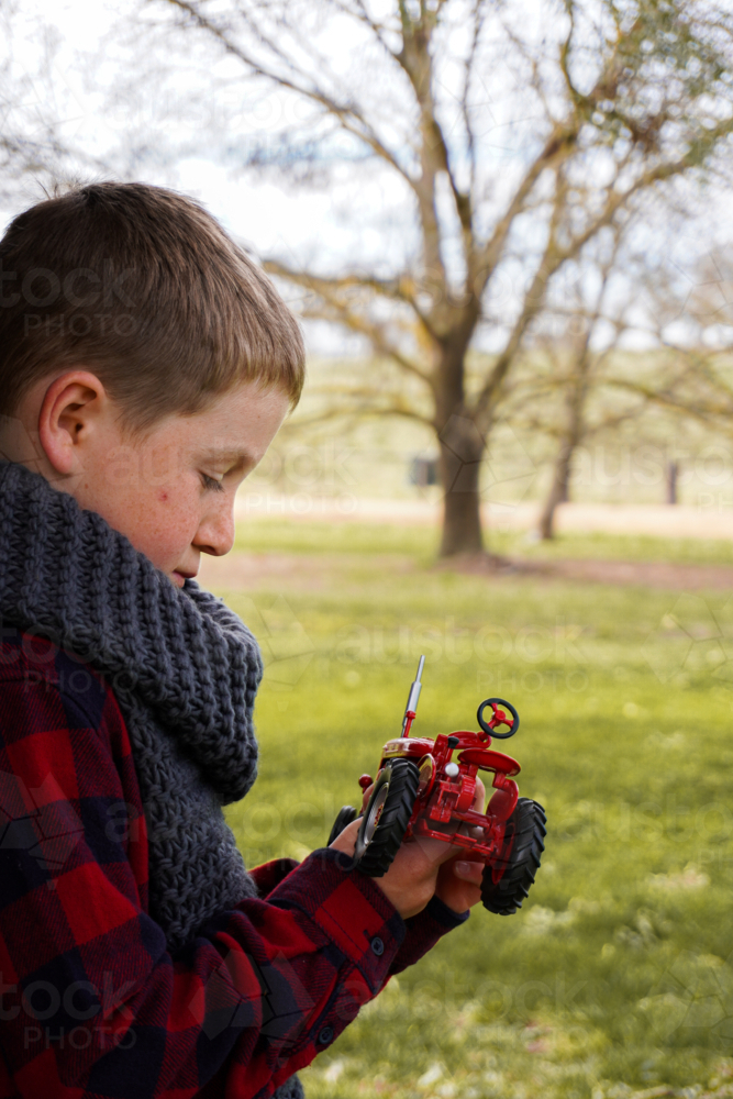 Young boy with an antique red model tractor - Australian Stock Image