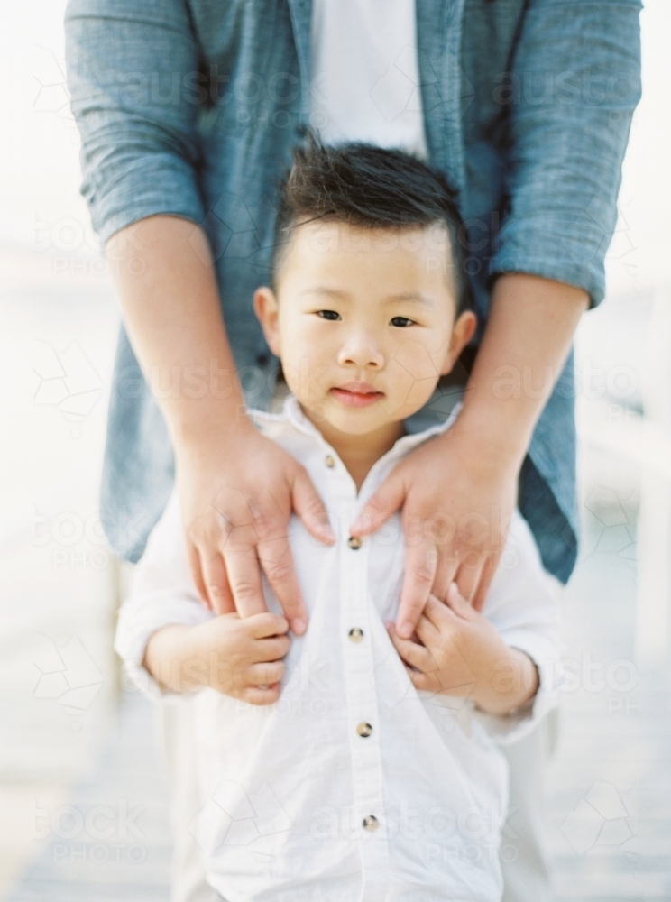 Young boy with his father standing behind him - Australian Stock Image