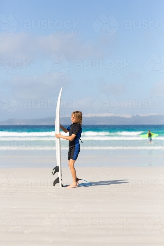 Young boy with surfboard on the beach - Australian Stock Image