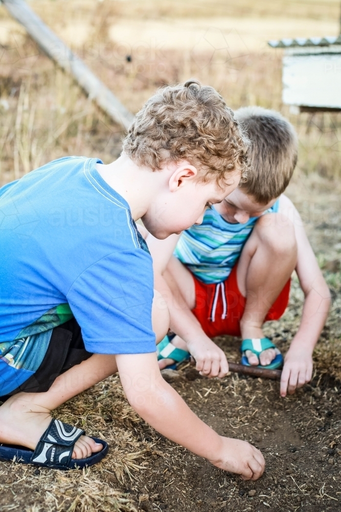 Young boys playing in dirt in drought - Australian Stock Image