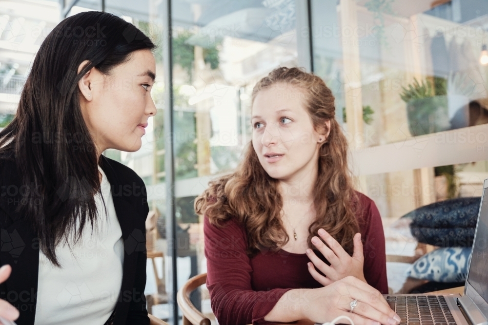Young business women having casual meeting at coffee shop - Australian Stock Image
