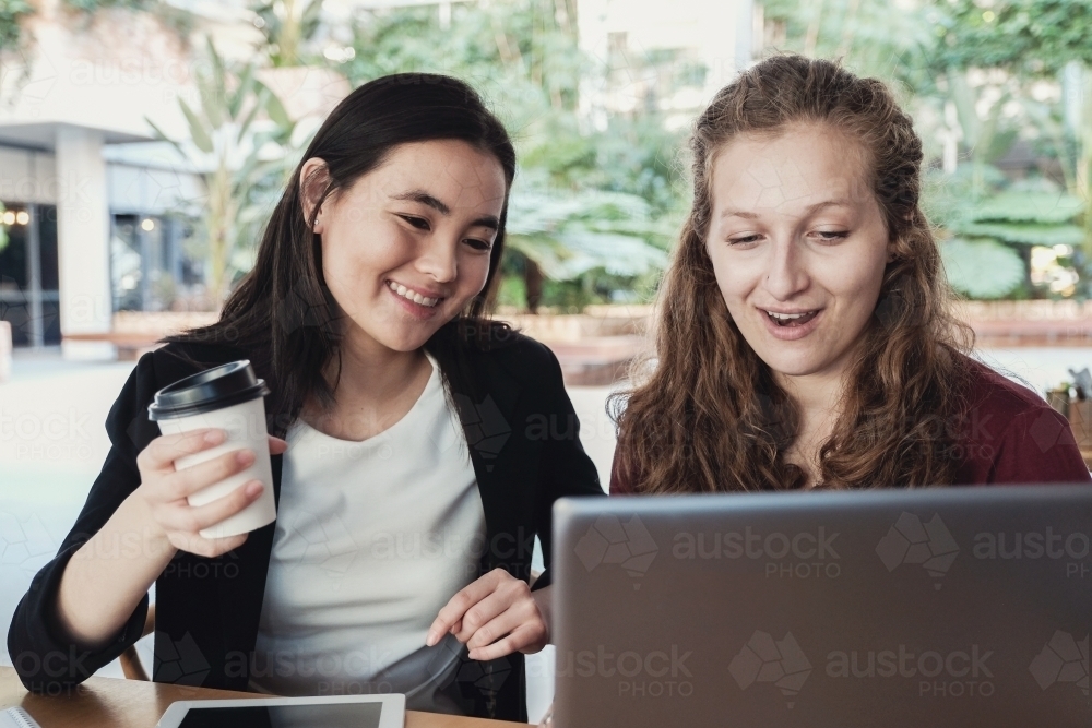 Young business women having casual meeting at coffee shop - Australian Stock Image