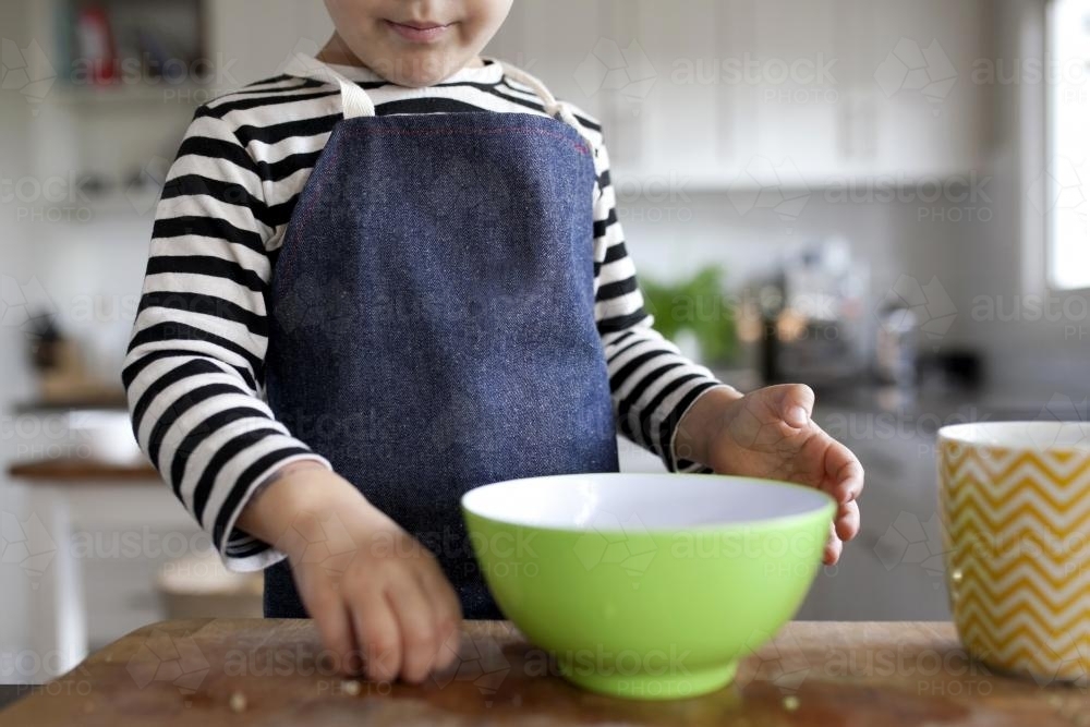 Young child helping in the kitchen - Australian Stock Image