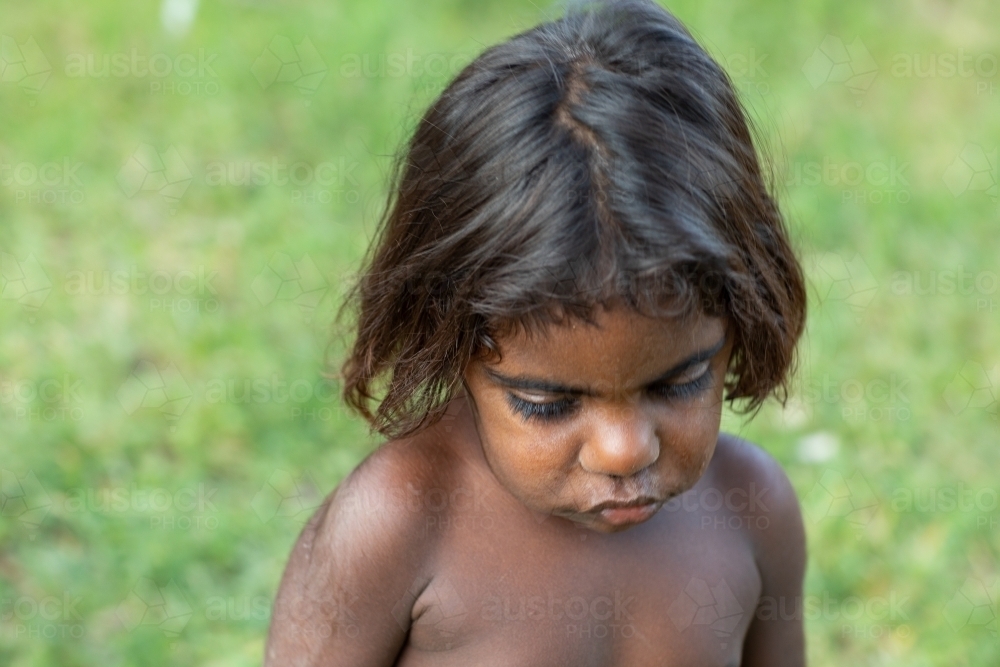 young child looking down seen from above with blurry background - Australian Stock Image