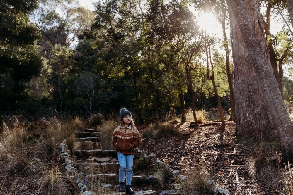 Young child on bush walk with sunlight through trees - Australian Stock Image