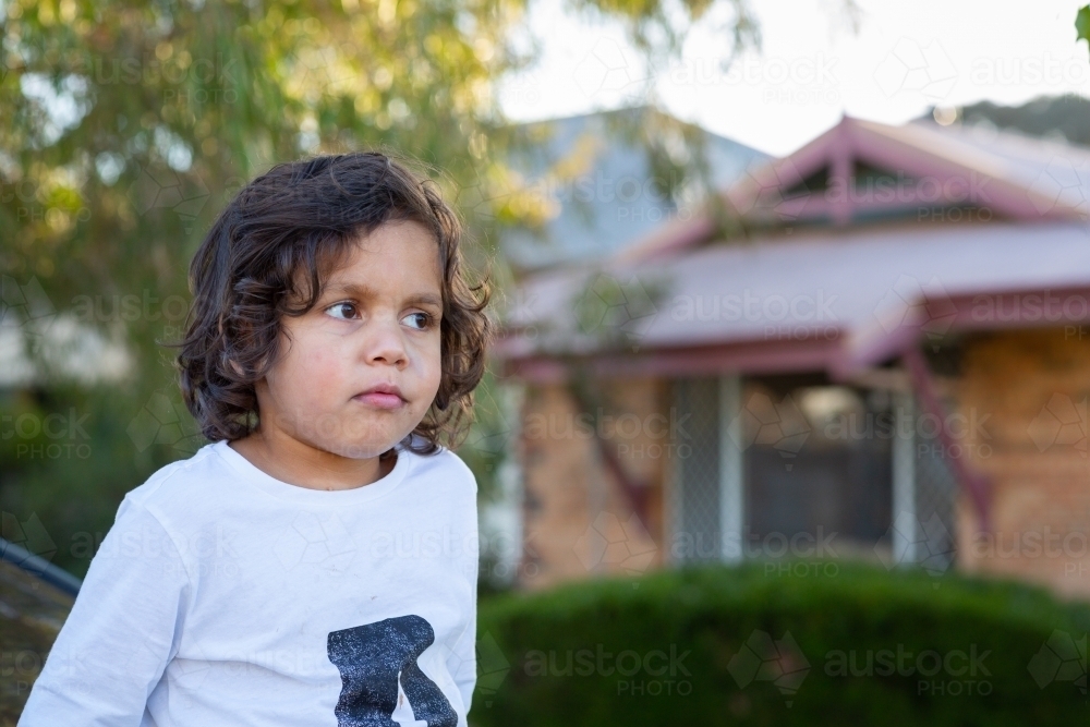 Young child outside his home - Australian Stock Image