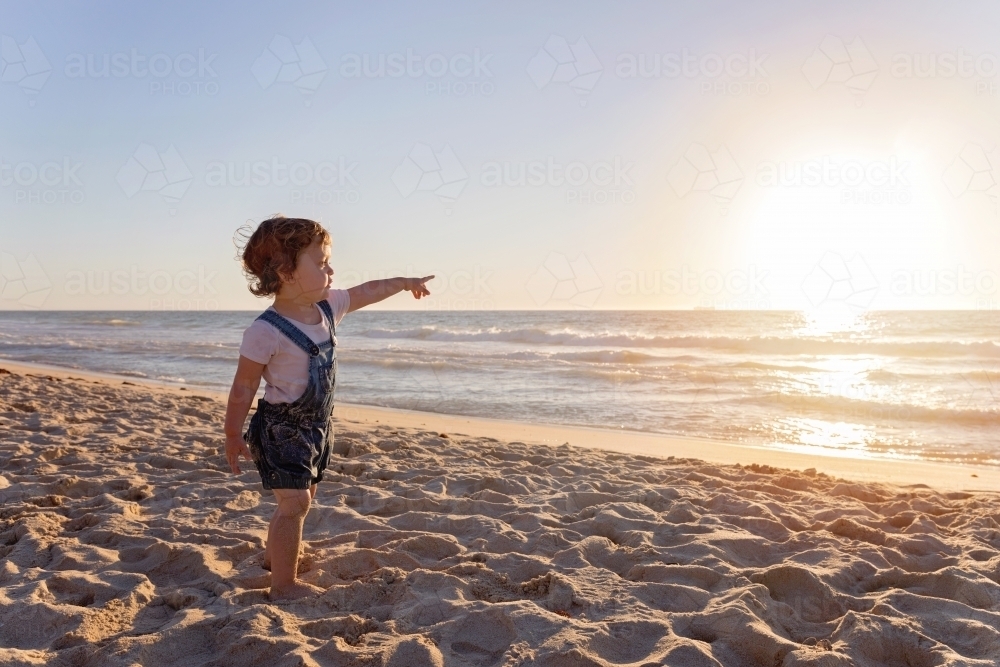Young Child Pointing At The Ocean At Sunset - Australian Stock Image