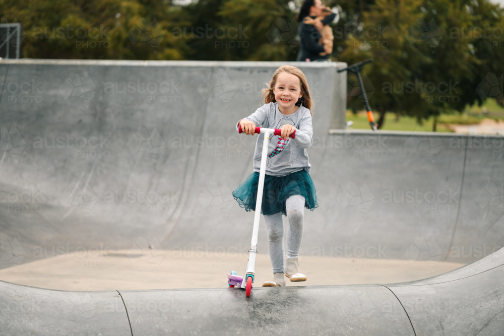 Young child riding scooter at skate park. Active child outdoors. - Australian Stock Image